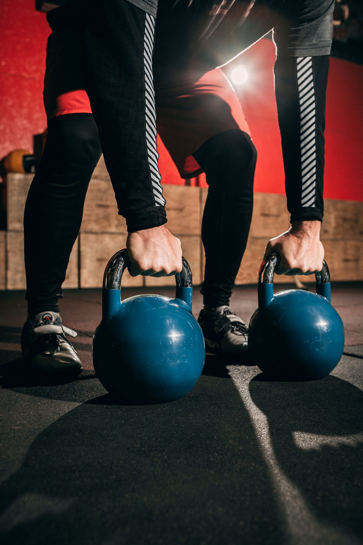 Hands gripping two kettlebells